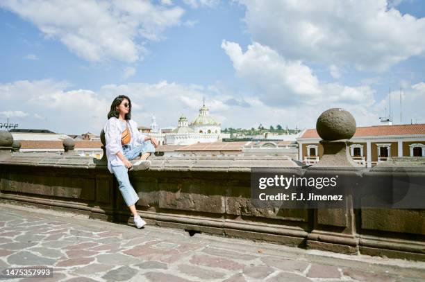 woman sitting in the square of san francisco de quito, ecuador - quito stock-fotos und bilder