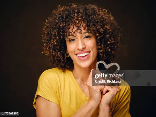 happy young woman holding inivisible teeth aligners - invisível imagens e fotografias de stock