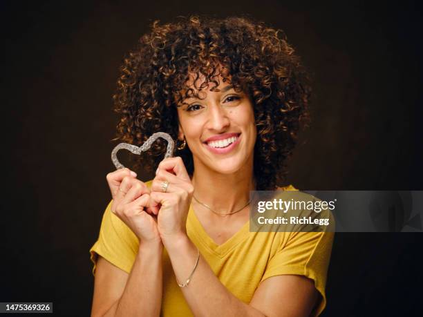 happy young woman holding inivisible teeth aligners - invisible braces stock pictures, royalty-free photos & images