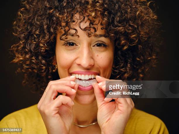 目に見えない歯のアライナーを持つ幸せな若い女性 - adult retainer ストックフォトと画像