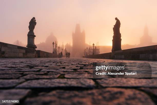 cobblestone of charles bridge at sunrise, prague, czech republic - karlsbrücke stock-fotos und bilder