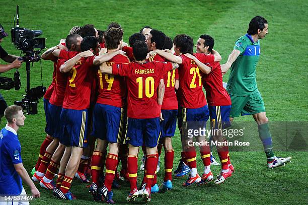 Spain players celebrate victory as Gianluigi Buffon of Italy walks by after the UEFA EURO 2012 final match between Spain and Italy at the Olympic...