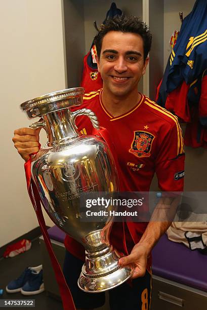 Xavi Hernandez of Spain poses with the trophy in the dressing room following the UEFA EURO 2012 final match between Spain and Italy at the Olympic...