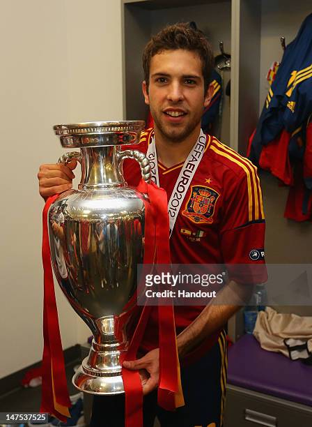 Jordi Alba of Spain poses with the trophy in the dressing room following the UEFA EURO 2012 final match between Spain and Italy at the Olympic...