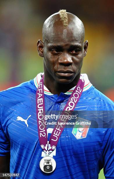 Mario Balotelli of Italy cries as he shows his dejection following defeat in the UEFA EURO 2012 final match between Spain and Italy at the Olympic...