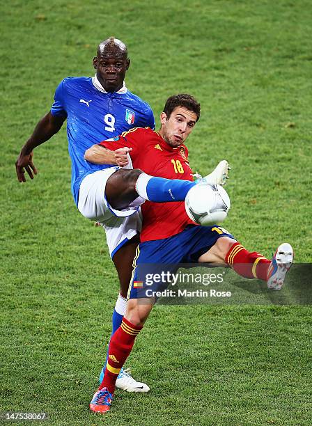 Mario Balotelli of Italy and Jordi Alba of Spain challenge for the ball during the UEFA EURO 2012 final match between Spain and Italy at the Olympic...