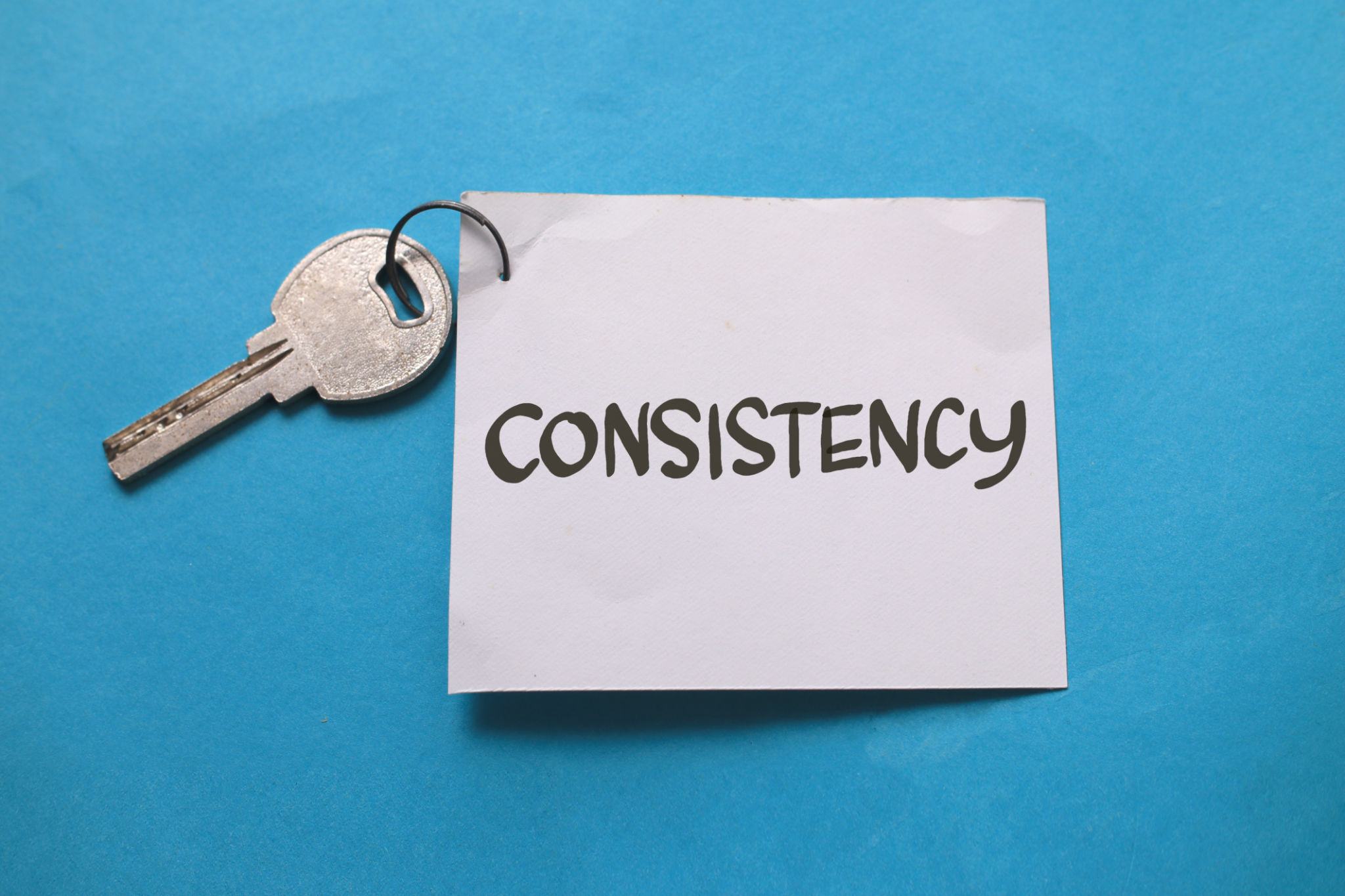 Consistency is the key, text words typography written on paper against blue background, life and business motivational inspirational Consistency is the key, text words typography written on paper against blue background, life and business motivational inspirational