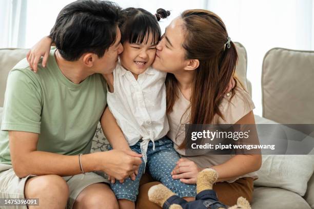 asian father and mother kissing daughter cheek with love, family relationship concept - asian mom kid kiss bildbanksfoton och bilder