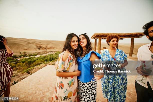 medium wide shot of twin sisters on vacation at luxury desert camp - confidence family stock pictures, royalty-free photos & images