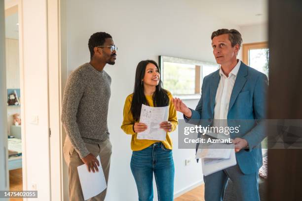 future house owners indoors doing a visit with a real estate agent - real estate agent stock pictures, royalty-free photos & images