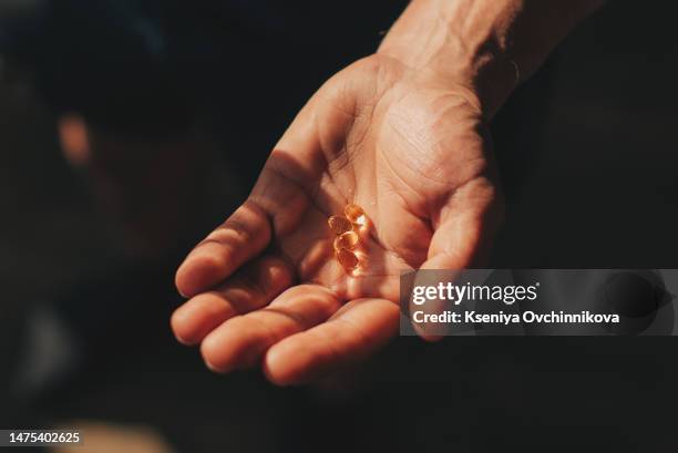 medicine in hand. patient committing suicide by overdosing on medication. close up of overdose pills and addict. sad unhappy millennial european man holding many different drugs on palm, top view - omega 3 stockfoto's en -beelden