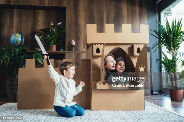 mother and children playing role play game at home with castle made of cardboard - princess castle stock pictures, royalty-free photos & images