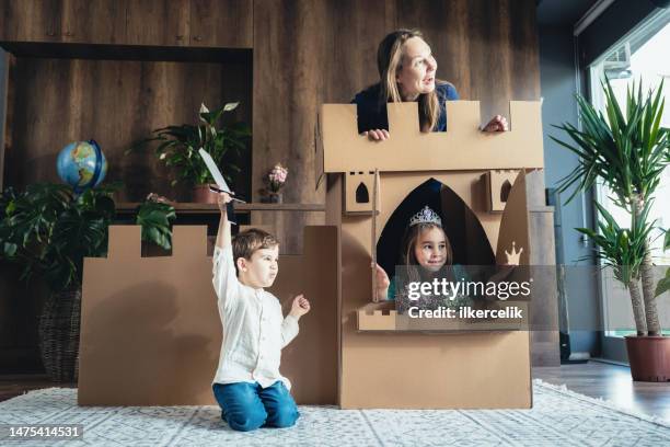 mother and children playing role play game at home with castle made of cardboard - princesse stock pictures, royalty-free photos & images