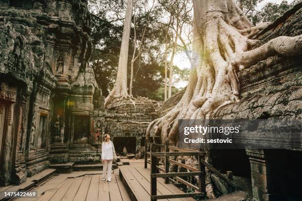 traveler exploring ancient ruins of ta prohm temple at angkor - angkor wat stock pictures, royalty-free photos & images