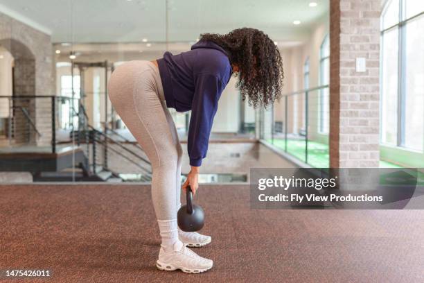 woman doing deadlifts with kettlebell weight at the gym - levantamento terra imagens e fotografias de stock