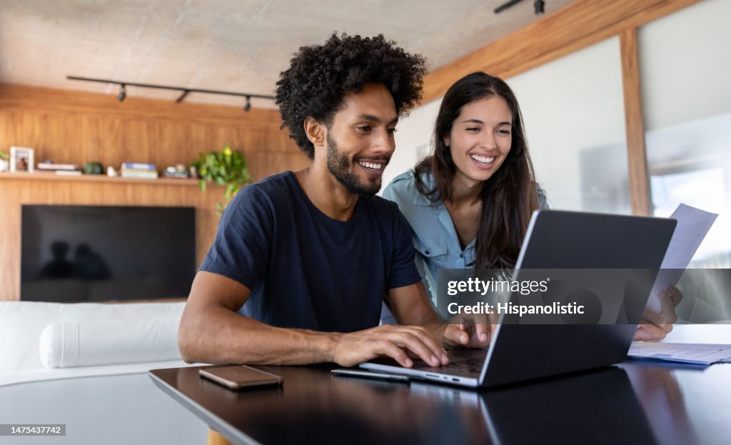 Young couple paying bills online using a laptop