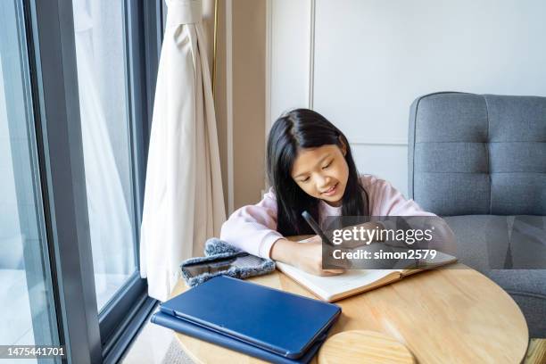 little asian girl studying at home - little asian girls stock pictures, royalty-free photos & images