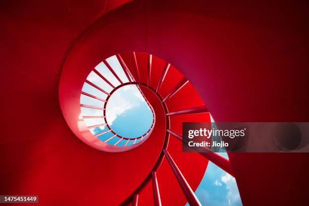 red spiral staircase against sky - spiral staircase fotografías e imágenes de stock