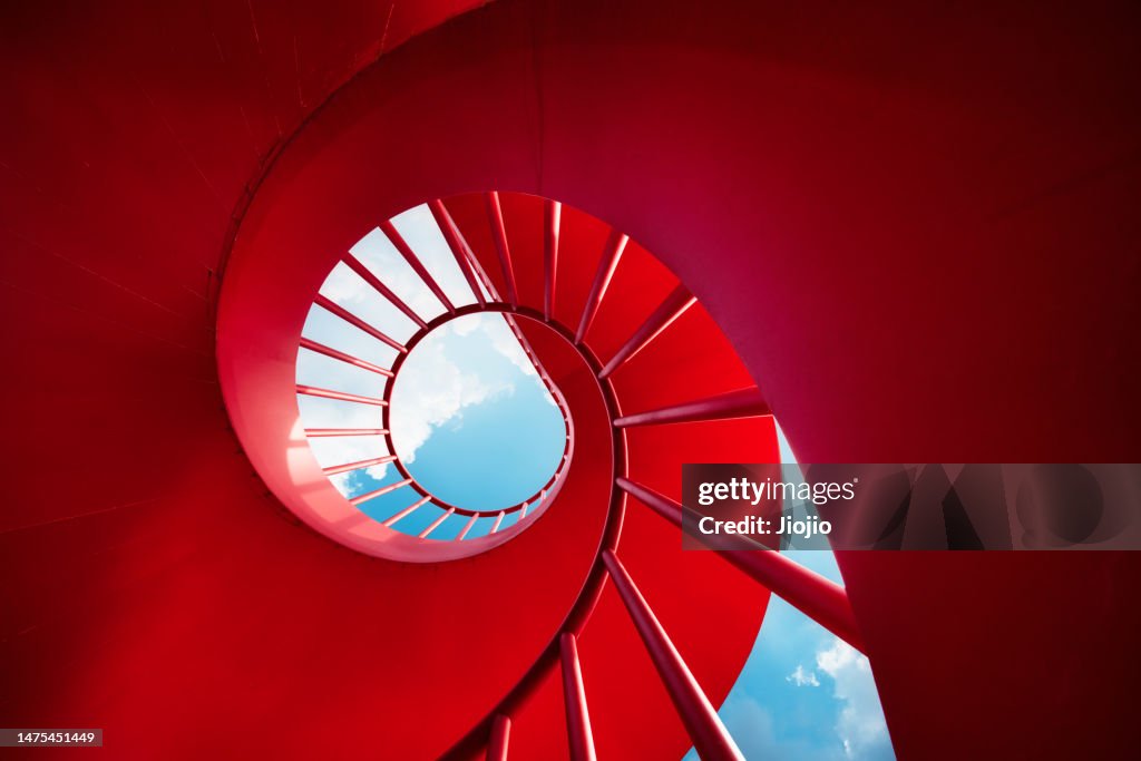Red spiral staircase against sky