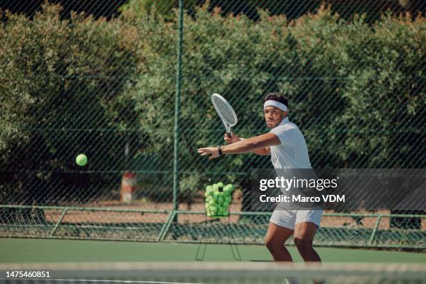 indian man, sports or playing on tennis court in exercise, training or workout for competition, challenge or cardio games. athlete, fitness or person hitting ball with racket in healthcare wellness - young tennis player stock pictures, royalty-free photos & images