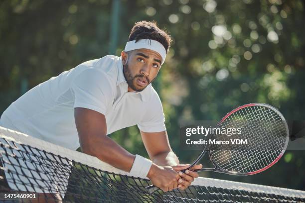 stanchezza, relax o uomo stanco sul campo da tennis dopo una partita o una partita di allenamento su erba per fitness o benessere. atleta indiano sano in pausa durante l'allenamento sportivo, l'allenamento o l'esercizio a riposo con la rete - stage light foto e immagini stock