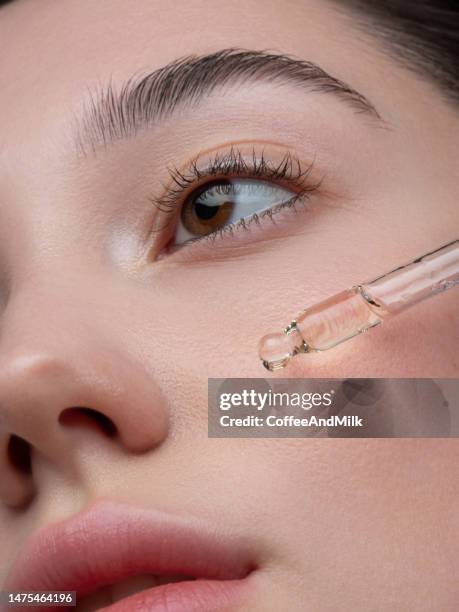 ritratto ravvicinato di bella ragazza che sta ricevendo il trattamento anti-invecchiamento della pelle - olio ed essenze foto e immagini stock