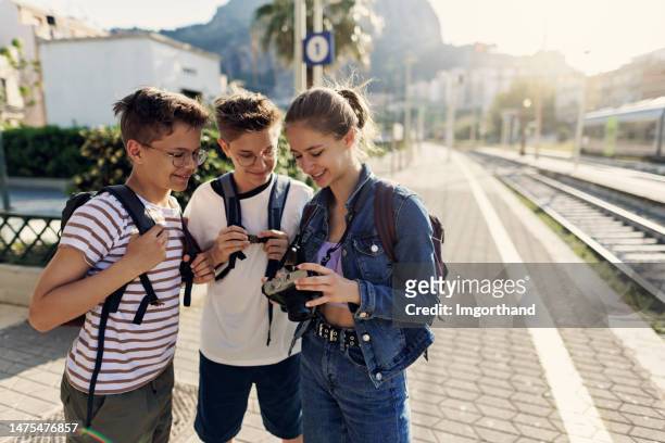 teenage kids tourists waiting for the train at the train station - boys and girls town stock pictures, royalty-free photos & images
