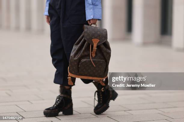 Tara Tut seen wearing Louis Vuitton black logo high boots, Louis Vuitton vintage logo backpack, Zara cropped pinstripes blue blouse and Zara...