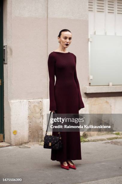 Mary Leest wears a burgundy maxi dress, black floral print bag and red heels outside Lanvin Paris Fashion Week - Womenswear Fall Winter 2023 2024 :...