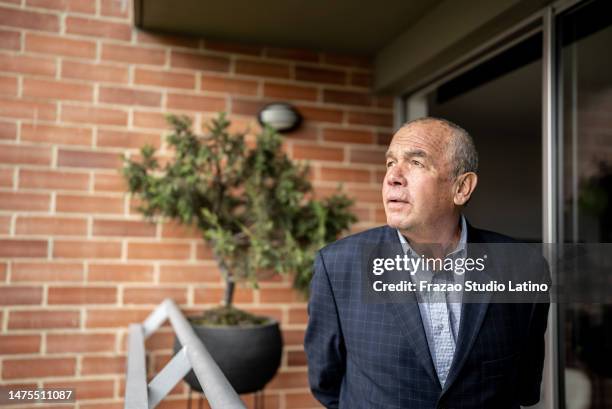 senior man contemplating on the balcony at home - dedication brick stock pictures, royalty-free photos & images