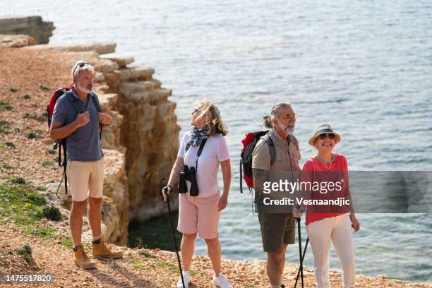 happy mature friends on holiday hiking close to the sea - cyprus stock pictures, royalty-free photos & images