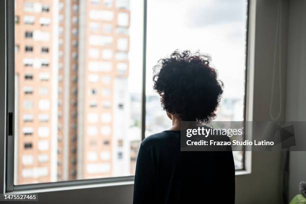 rear view of a senior woman contemplating at home - people silhouettes stock pictures, royalty-free photos & images