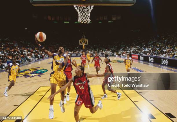 Penny Toler, Guard for the Los Angeles Sparks drives to the hoop to make a lay up shot over Cynthia Cooper of the Houston Comets during their WNBA...