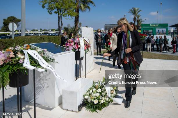 Woman belonging to the Association of Victims of Germanwings flight 9525, places a flower next to a memorial plaque during a tribute to the victims...