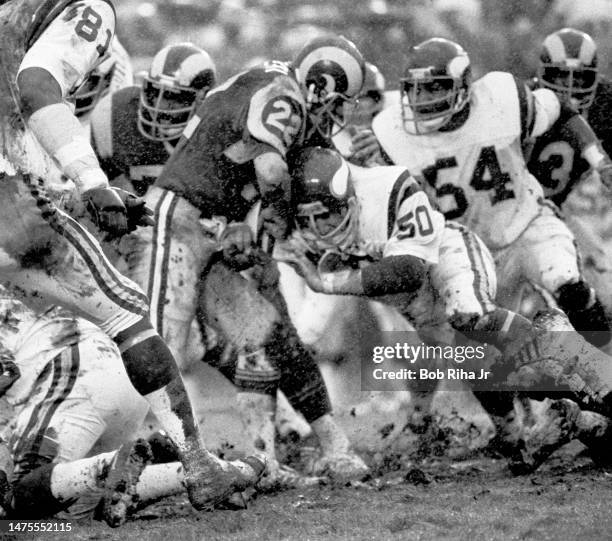 Rams RB John Cappelletti is stopped by Vikings Linebackers Jeff Siemon and Fred McNeill during rainstorm at NFC Playoff Game between Los Angeles Rams...