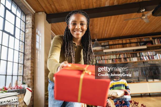 retrato sincero de una niña presentando un regalo a la cámara - giving a girl head fotografías e imágenes de stock