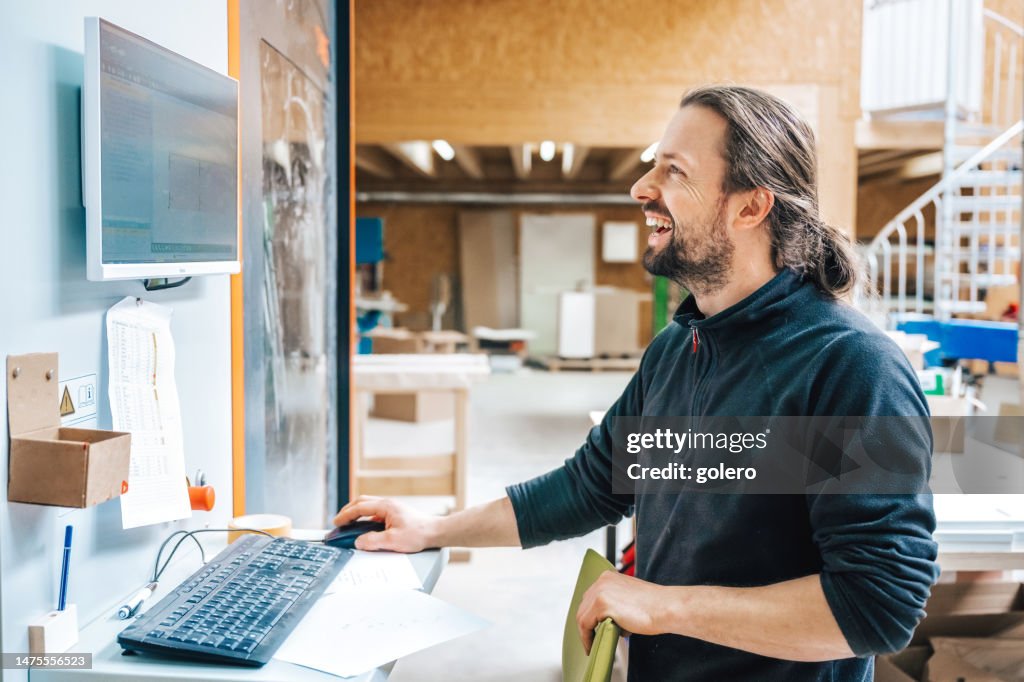 Glücklicher Schreiner bei der Arbeit mit CNC-Fräsmaschine