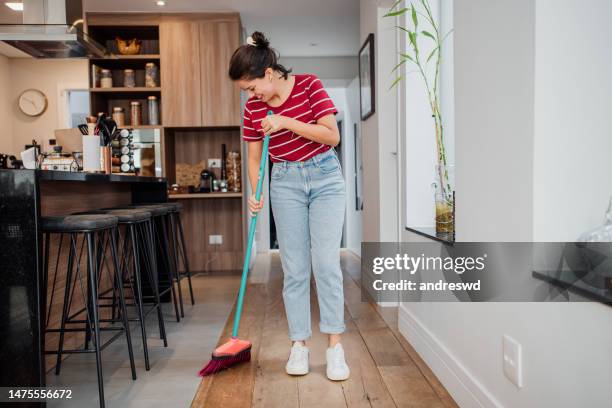 woman sweeping the floor of the house - vegen stockfoto's en -beelden