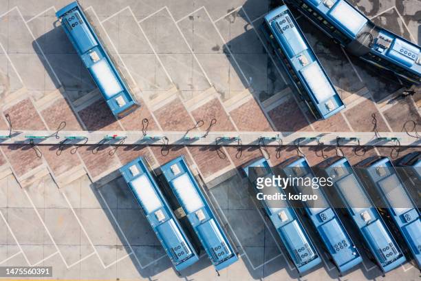 aerial view of electric bus charging at charging station - fleet of vehicles stock pictures, royalty-free photos & images