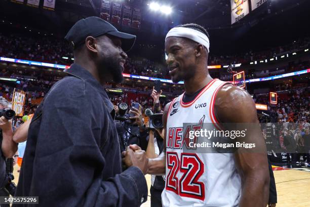 Former Miami Heat player Dwyane Wade and Jimmy Butler of the Miami Heat meet on the court after a game against the New York Knicks at Miami-Dade...