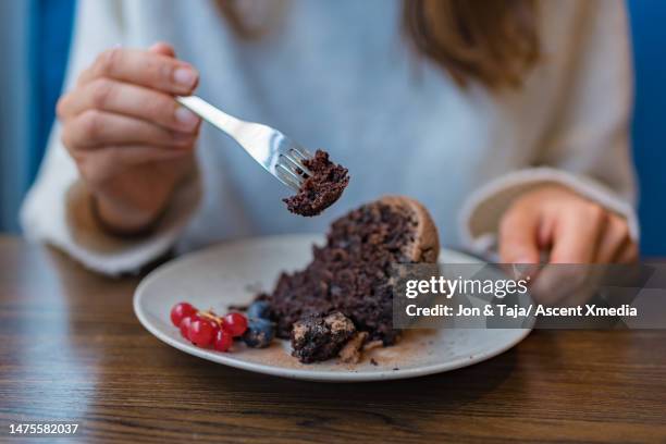 woman eats chocolate cake and fresh berries - chocolate cake stock pictures, royalty-free photos & images
