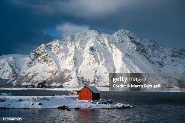 red cabin in a fjord in winter - fishing village photos et images de collection