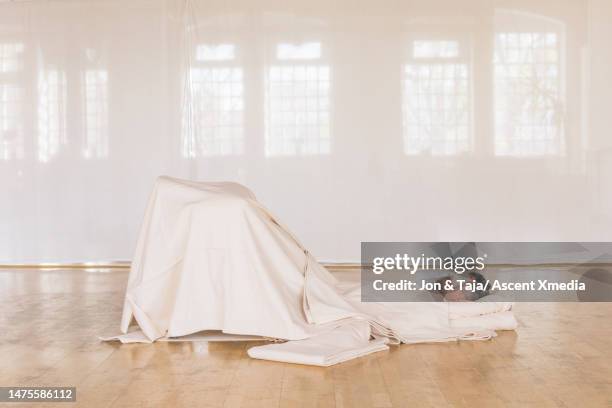 man enjoys restorative yoga in studio - luxury pyjamas stock pictures, royalty-free photos & images