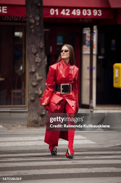 Nina Sandbech is seen wearing full red outfit, red pants, red long leather coat, red bag, red leather gloves, black wide belt, Loewe shoes with...