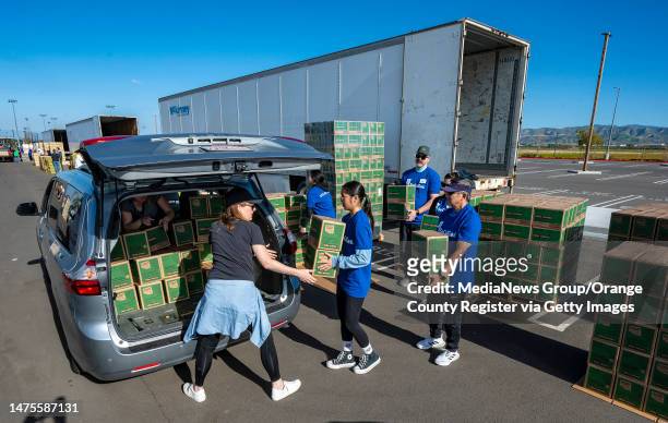 Irvine, CA Girl Scout troop leaders and volunteers carry some of one million packages of Girl Scout cookies to a van during the Mega Delivery Girl...