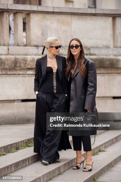 Caroline Daur is seen wearing Tiffany and Co. City hardware yellow gold diamond necklace, black cat-eye sunglasses, a black corset, a black blazer...