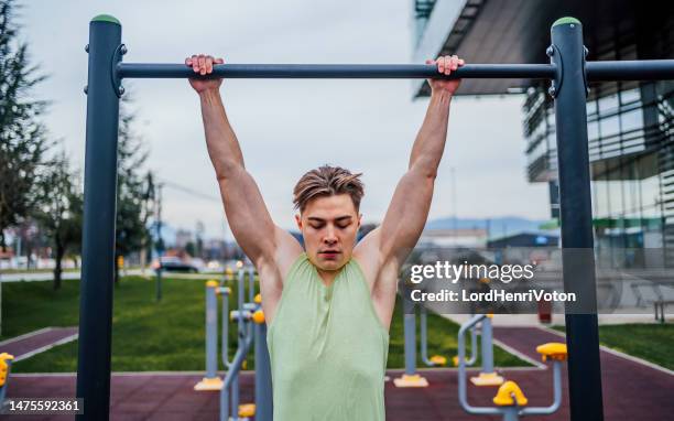 sporty man exercising in a recreational park - chin ups stock pictures, royalty-free photos & images