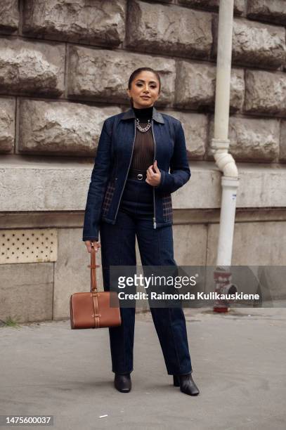 Guest is seen wearing a blue denim jacket, jeans, black sheer top, brown tan bag, outside the Hermes show during Paris Fashion Week - Womenswear Fall...