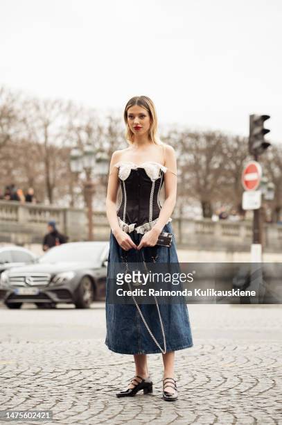 Danielle Marcan seen wearing a complete Vivienne Westwood look with a denim shoulder free corsage, a jeans skirt, black ballet flats and a black...