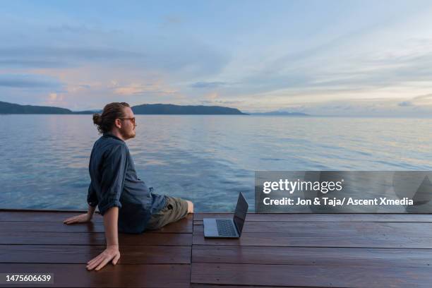 young woman meditates on dock at sunrise - man ponytail stock pictures, royalty-free photos & images